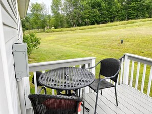 A deck with a table and two chairs, overlooking a grassy yard. - Escape to Serenity: 18-Acre Catskill Retreat (Margaretville)