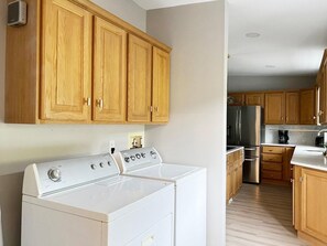 Una cucina con mobili in legno, un piano cottura bianco e un frigorifero in acciaio inossidabile.