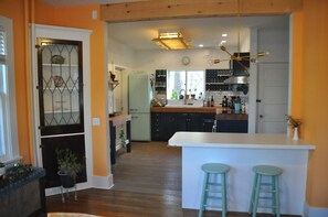Una cocina con una isla central, taburetes de bar y un ventanal con vistas.