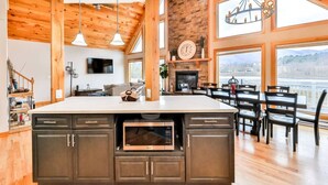 A spacious kitchen with a large island, wooden ceiling, and a fireplace. - Lakeside Catskills Escape • Soak, Sip & Stargaze (Cairo)