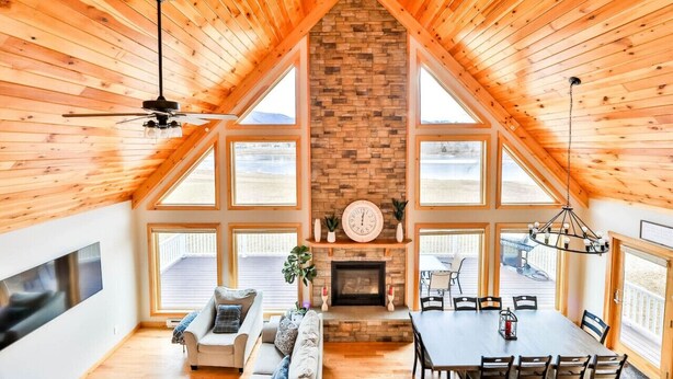 A spacious loft with a high ceiling, large windows, a fireplace, and a dining area. - Lakeside Catskills Escape • Soak, Sip & Stargaze (Cairo)