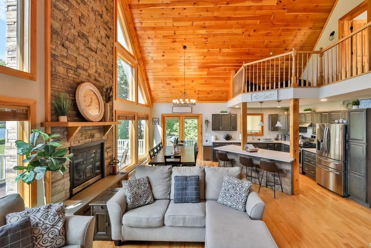 A spacious living area with a fireplace, a sofa, and a dining table.