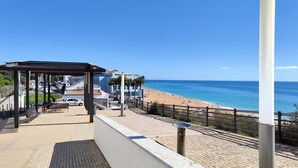 A beachside view with a gazebo, a paved walkway, and a building labeled "Pera Hotel".