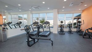 A gym with treadmills, elliptical machines, and weight benches.