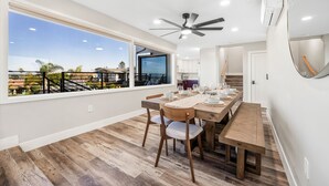 A dining area with a large window, a ceiling fan, and a view of the outdoors.