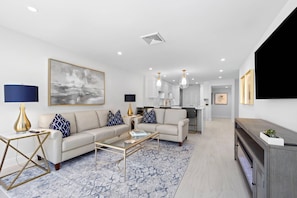 A modern living room with a sofa, coffee table, and a TV.