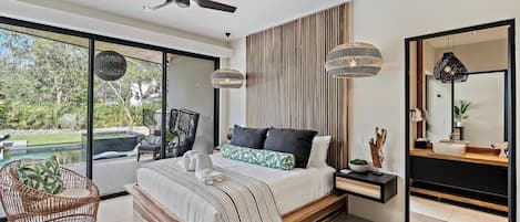 A modern bedroom with a large bed, a ceiling fan, and a view of the outdoors.