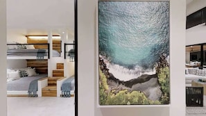 Un interior modern amb un llit superposat, una obra d'art gran emmarcada i una zona de seients.