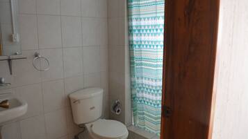 A bathroom with a toilet, sink, and a shower curtain.