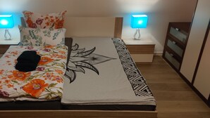 A bed with floral bedding, a black towel, and a patterned blanket. There are two bedside tables with lamps. - Vacation apartment 94 sqm & 16 sqm terrace - with magnificent panoramic views of the city and the Alps (Waldshut-Tiengen)