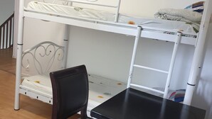 A bunk bed with a black chair and a small table in a room with wooden flooring. - Auberge Rose - Hostel (Noisiel)