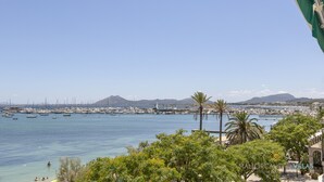 A coastal marina with boats, palm trees, and a clear sky. - Apartamento Tonia by Mallorca North Villas (Port de Pollença)