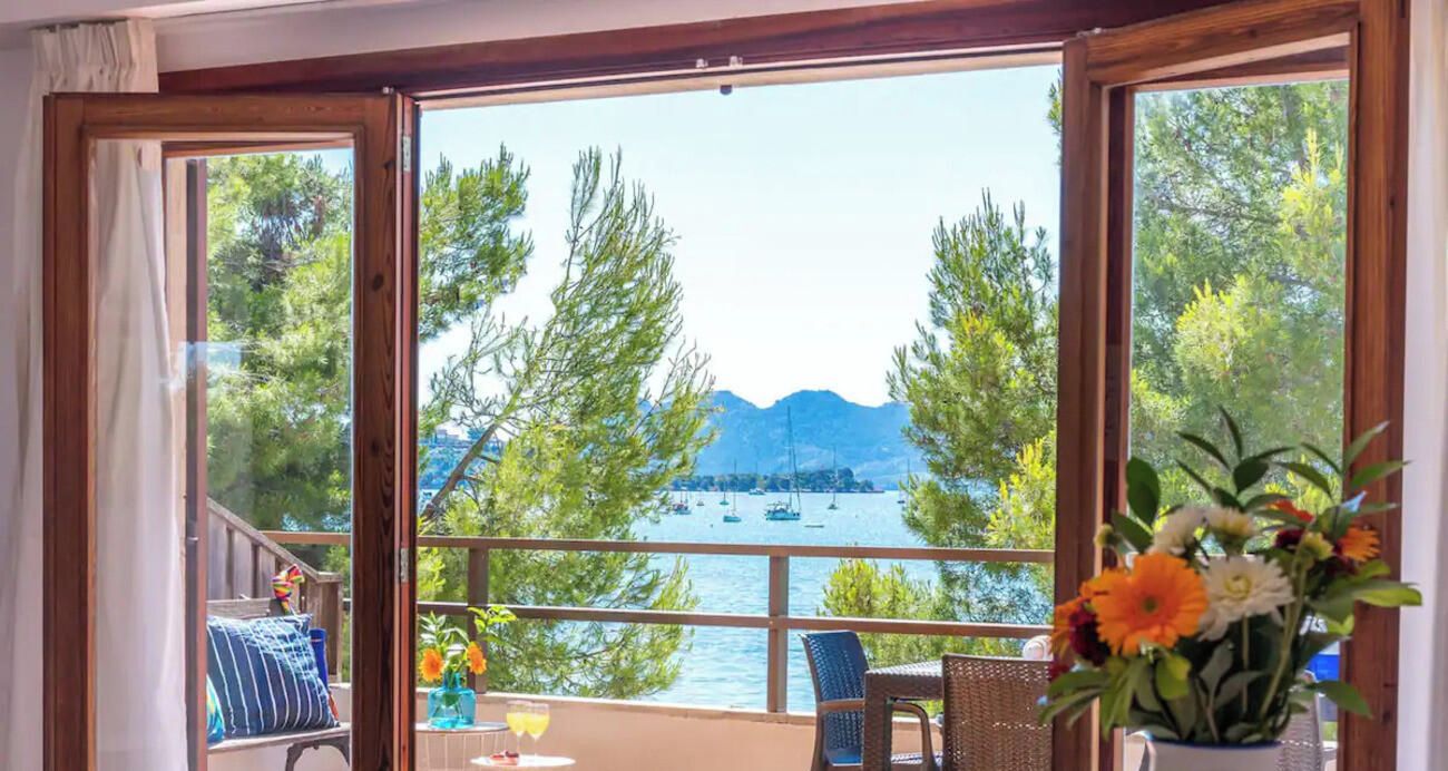 Una habitación con un ventanal que ofrece vistas a un lago y montañas.
