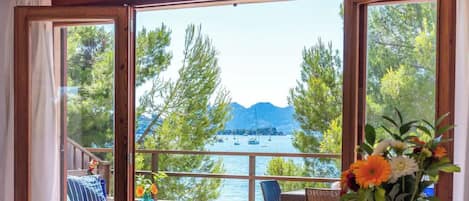 Una habitación con un ventanal que ofrece vistas a un lago y montañas.