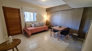 Una stanza accogliente e di dimensioni ridotte, con un letto, un tavolo e delle sedie.