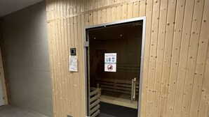 Puupaneloitu huone, jossa on ovi, joka johtaa suihkutilaan.