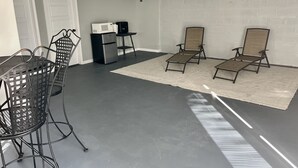 Espaço compacto com mesa e cadeiras de jantar, cozinha compacta e duas poltronas.