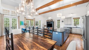 Una cocina amplia con vigas de madera, una isla grande y electrodomésticos modernos.