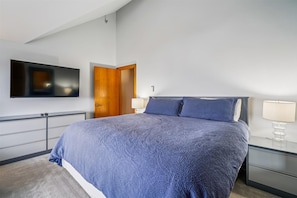King Bedroom with TV - Primary bedroom with king bed, bedside lighting, dresser storage, and a mounted flat-screen TV.