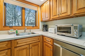 Fully Equipped Kitchen - Bright kitchen with generous counter space, full appliances, and a window that brings in natural light while you cook.