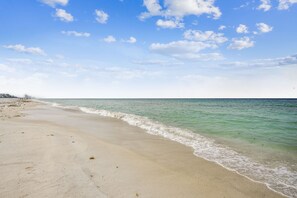 A beach with clear water and a sandy shore.