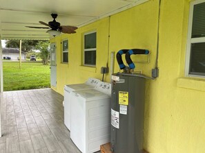 A laundry area with a washing machine and dryer, a ceiling fan, and a utility box with an energy guide sticker.