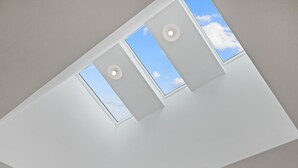 Et loft med ovenlysvinduer og indbygget belysning.