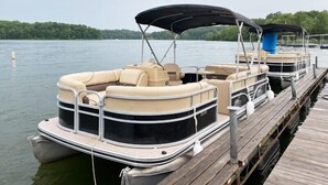 A pontoon boat docked at a wooden pier with a canopy. - Family Lakefront Cabin! Hot Tub, Arcades & Dock (Wautoma)