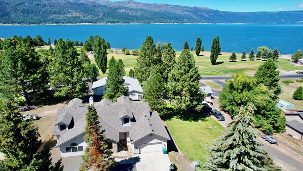 Zona residencial con casas, un campo de golf y un lago.