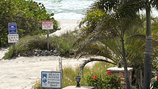 Señal de acceso a la playa, señal de acceso a la playa y señal de acceso a la playa con un pilar de piedra y un farol.