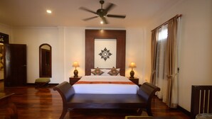 A bedroom with a large bed, two bedside tables with lamps, a ceiling fan, and a wooden floor. - Lux hotel Luang Prabang (Luang Prabang)