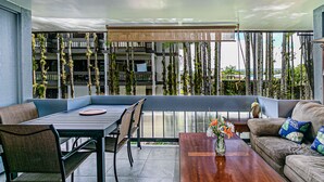Een moderne zithoek buiten, met een tafel, stoelen en een bank.