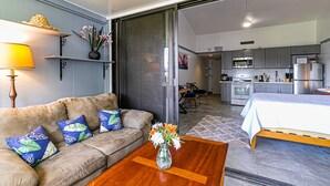 Een moderne woonkamer met een bank, salontafel en een vaas met bloemen.