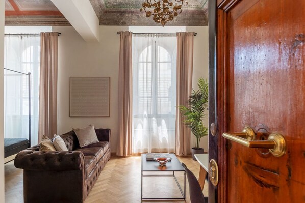 A living room with a sofa, a coffee table, and a potted plant.