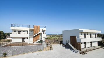 Two modern buildings with a clear view of the sea.