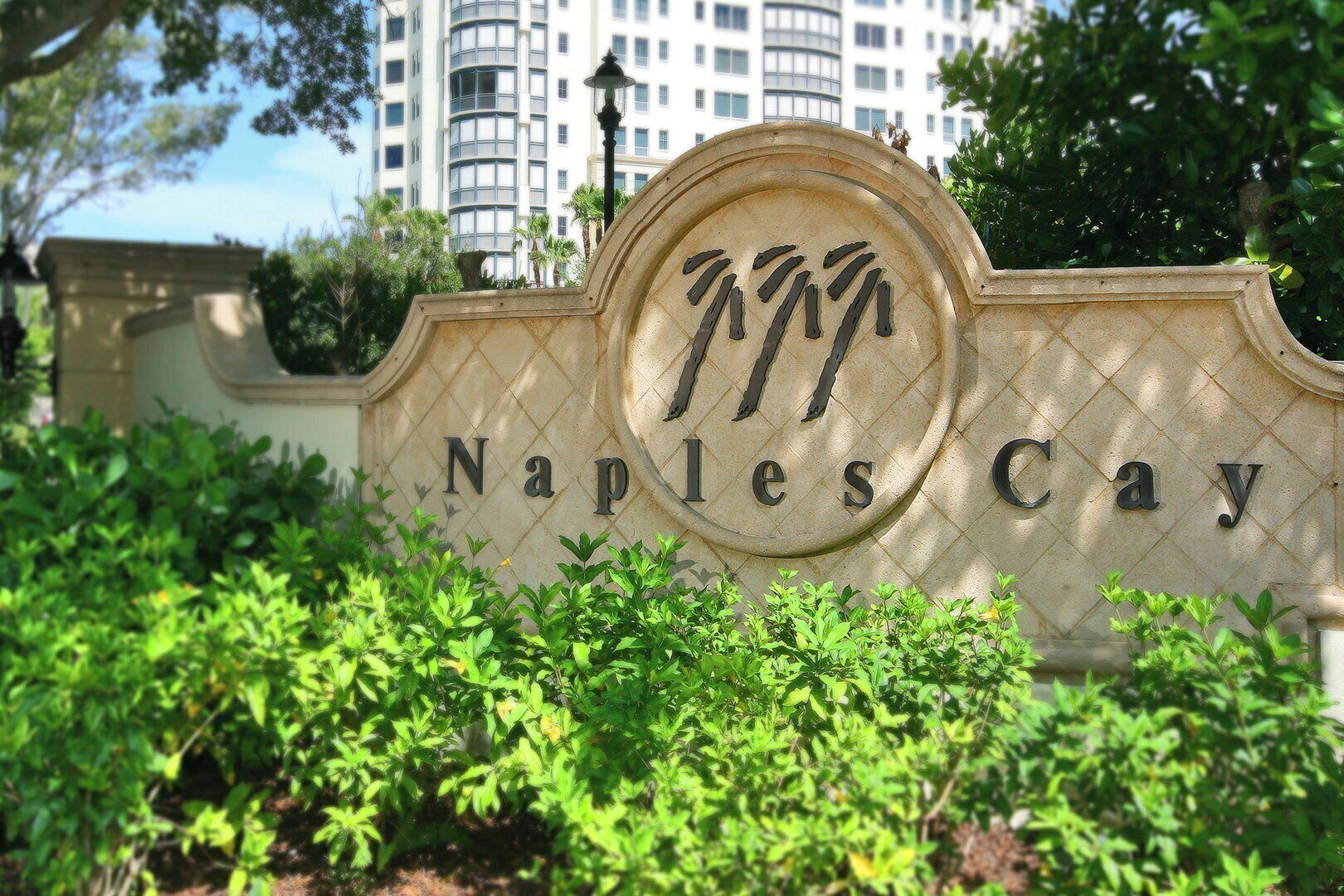 Ein Schild für Naples Cay mit einem kreisförmigen Emblem und dem Namen in Großbuchstaben.