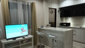 A modern kitchen with a TV, a coffee maker, and a microwave. - Elegant/ Centrally located townhouse. (Lapu-Lapu City)