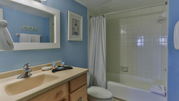 A bathroom with a sink, mirror, and shower. - Destin on the Gulf 606 (Destin)