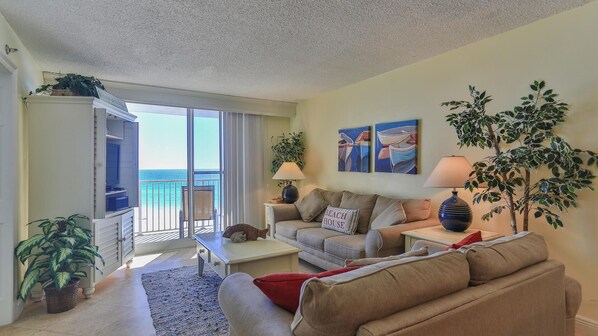 A living room with a balcony overlooking the ocean, a sofa, a coffee table, and two lamps. - Destin on the Gulf 606 (Destin)