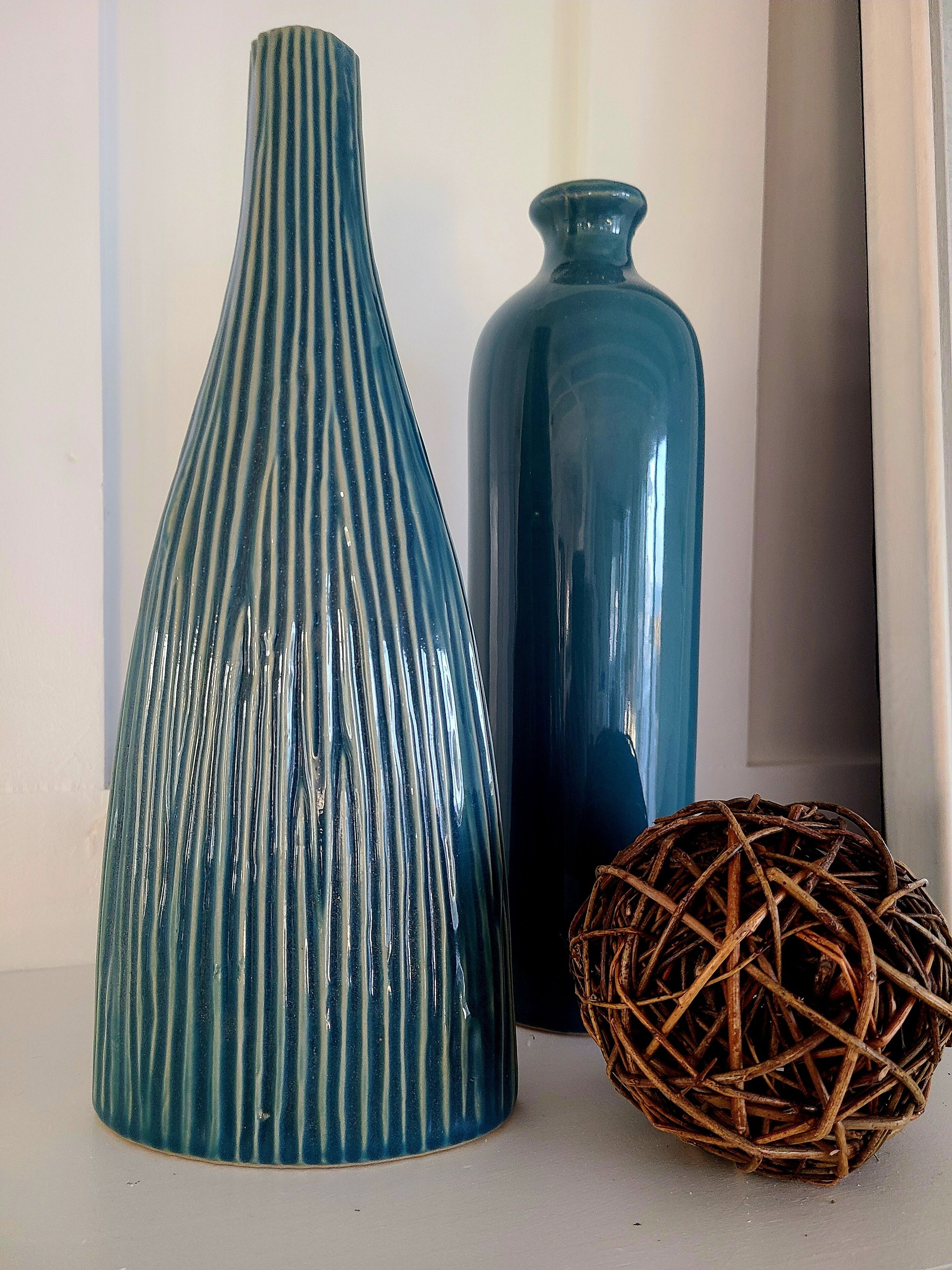 Deux vases et une balle tressée sur une table.