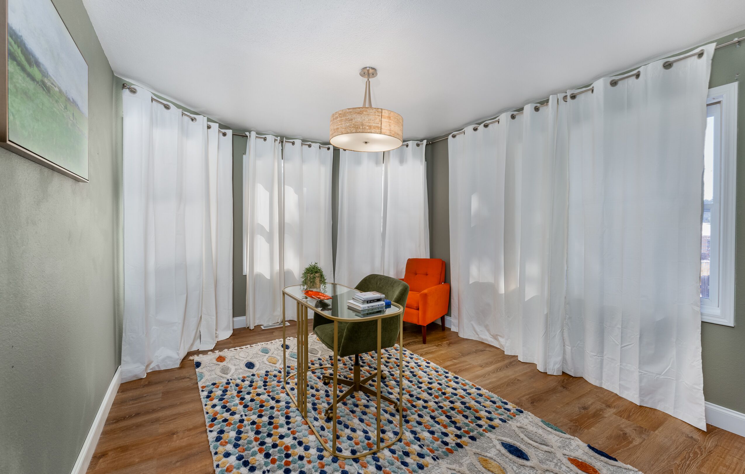 A room with a glass table, a chair, a rug, and a lamp.