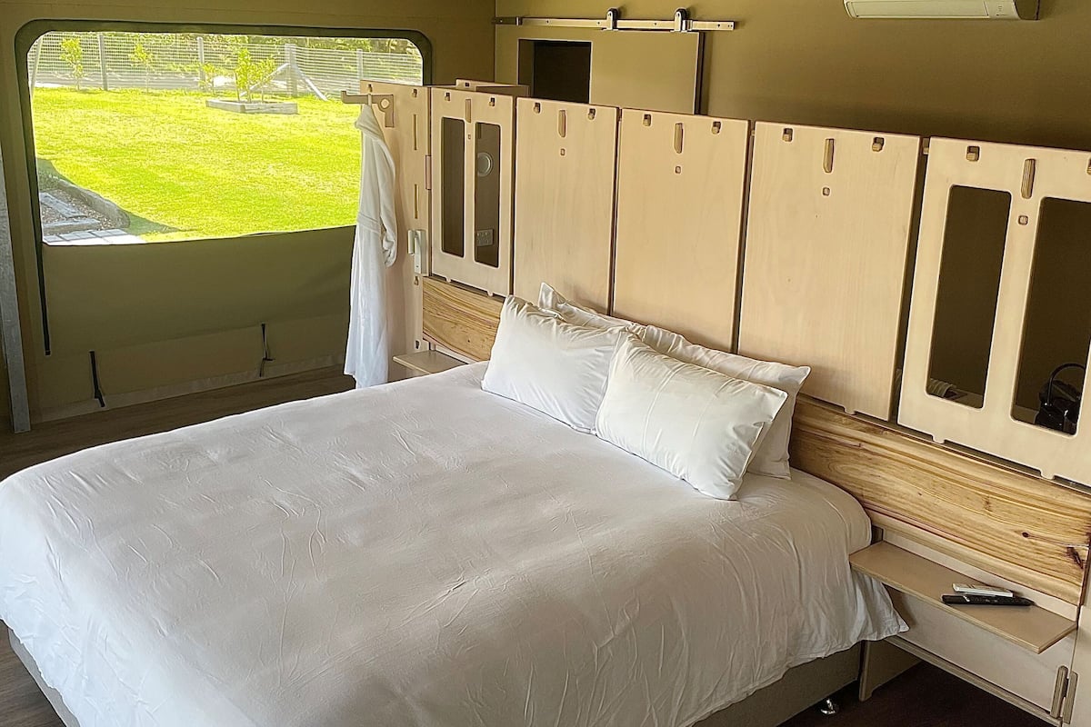 Ein Schlafzimmer mit Bett, Holz-Kopfteil und Deckenventilator.