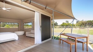 Una habitación amplia con una cama, un sofá, una mesa y un banco.