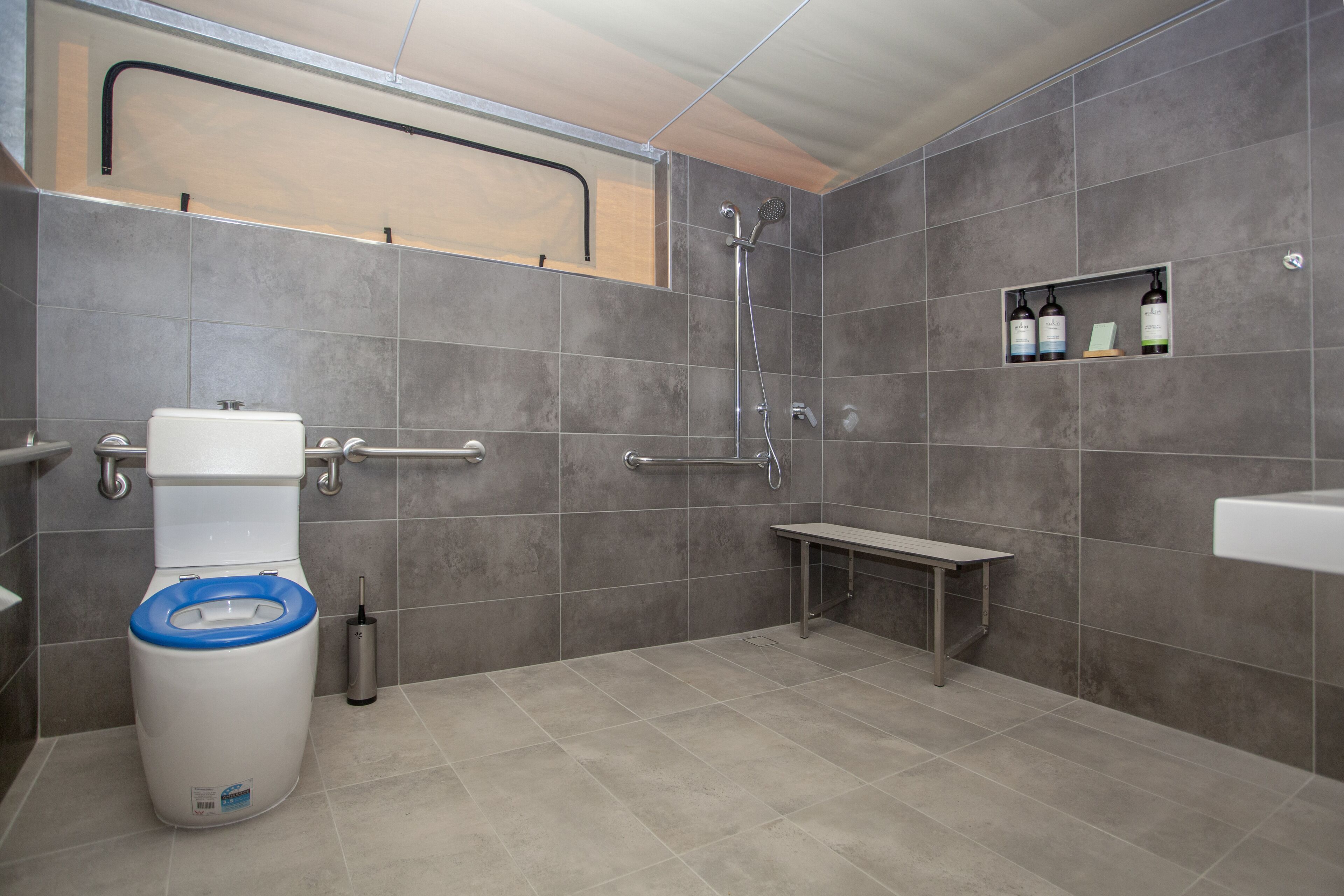 A modern bathroom with a toilet, shower, and sink.