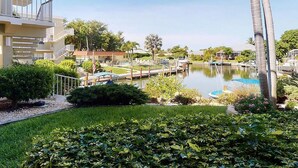 A hotel with a pool, palm trees, and a well-maintained garden. -  Charming Condo in Marco Island (Marco Island)