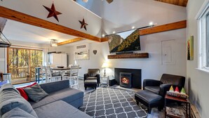 Ein gemütliches Wohnzimmer mit Kamin, bequemen Sitzgelegenheiten und einem großen Fernseher.