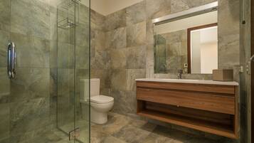 A modern bathroom with a glass shower enclosure, a toilet, and a wooden vanity with a mirror.