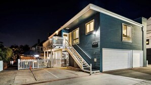 Une maison à deux étages avec un porche à l’avant, un escalier menant au deuxième étage et un garage.