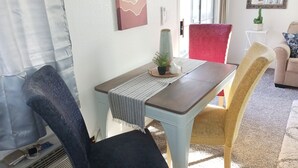 Ein Essbereich mit Tisch, Stühlen und einem Topf mit Pflanze.
