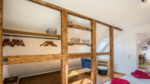 Een kamer met een houten stapelbed, houten planken en een blauwe stoel.